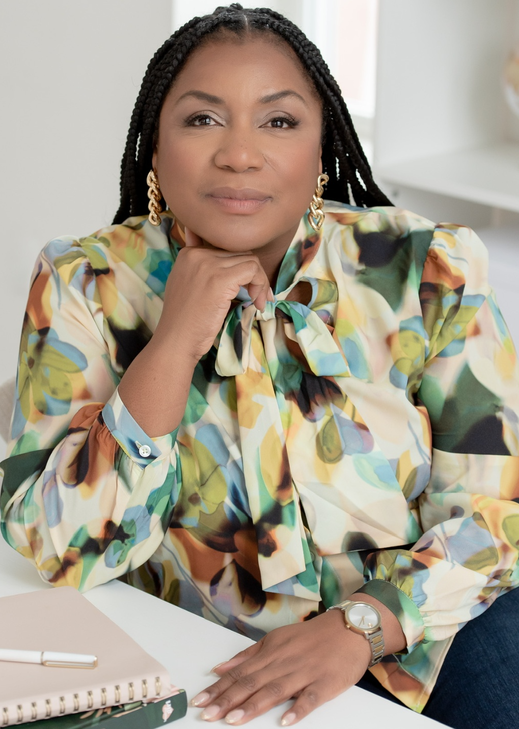 Khali Tabor, founder of Mamas to Be Sanctuary, seated at a bright table in a floral blouse